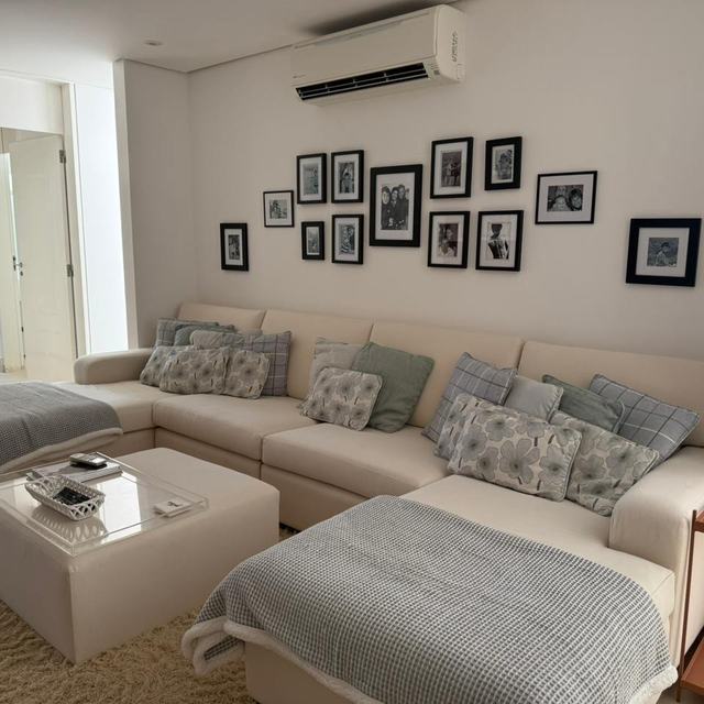 Sofá de canto bege com chaises e puff na sala de estar